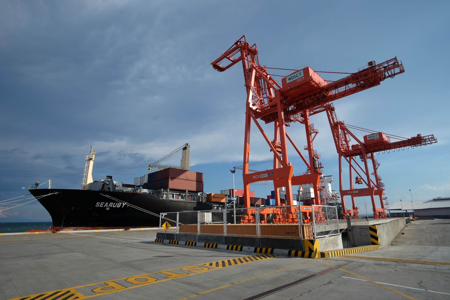 A container vessel berthed beneath gantry cranes at a Philippine container terminal